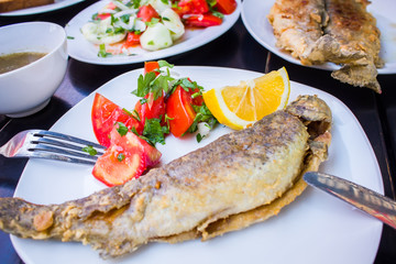 Fototapeta na wymiar fried fish with fresh herbs and lemon