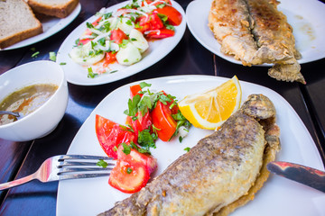 fried fish with fresh herbs and lemon
