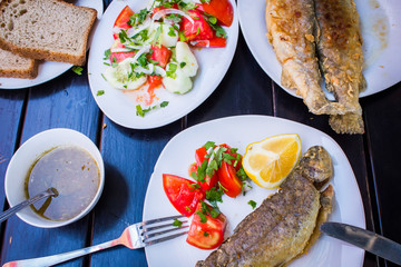 fried fish with fresh herbs and lemon