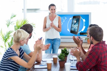 Composite image of colleagues clapping hands in a meeting