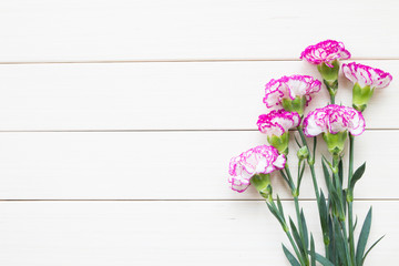 Pink carnations on wooden background