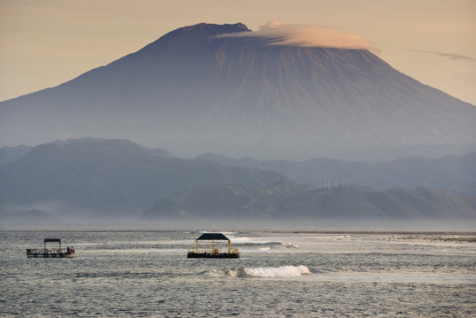 Mt. Agung From Nusa Lembongan. Sunrise View Of The Volcano Known As Gunung Agung As Seen From The Small Island Off The Coast Of Bali Known As Nusa Lembongan. This Island Has Seaweed Farms And Surfing.