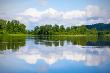 Obraz premium Beautiful landscape with blue sky and white clouds reflected in