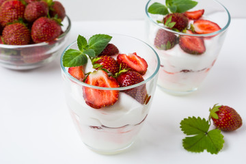 Fresh strawberries dessert layered with yogurt on white backgrou