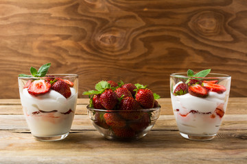 Strawberries dessert with whipped cream on rustic wooden backgro