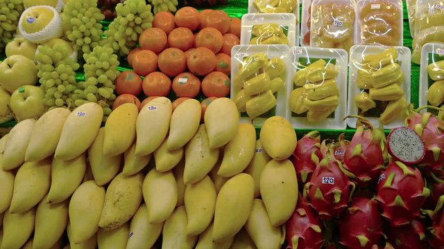 Fresh fruits, including mangoes, dragonfruit, apples, grapes, jackfruit, pomello and oranges, arranged for display in a Thai supermarket. UltraHD 4k footage