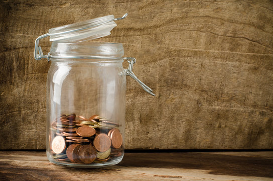 Coins in the bottle on wooden background,saving money concept