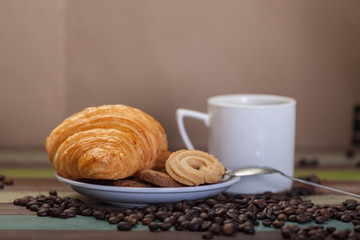 Cookies and croissant with coffee cup background