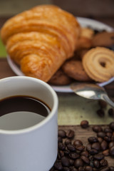Close up a cup of coffee with cookies