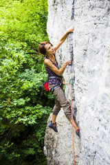 The girl climbs the rock.