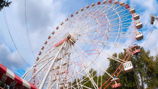 Ferris wheel in the amusement park against the backdrop of running thick clouds 