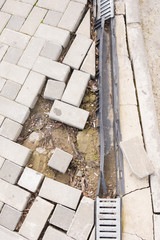 The destruction of the pedestrian walkway of stone tiles with drainage