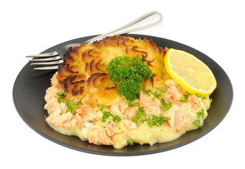 Portion of crispy potato topped fish pie on a black plate