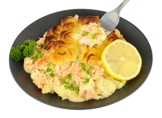 Portion of crispy potato topped fish pie on a black plate