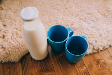 Fototapeta na wymiar a bottle of milk and blue cups