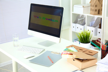 Designer working desk with a computer and paperwork