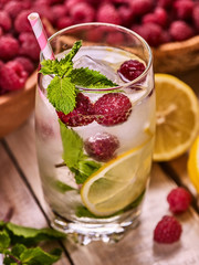 Alcohol cocktail. On wooden boards glasses with ice cubes alcohol cocktail. Cocktail number hundred sixty four cocktail raspberry mojito with lime and mint leaf. Top view of country outdoor.