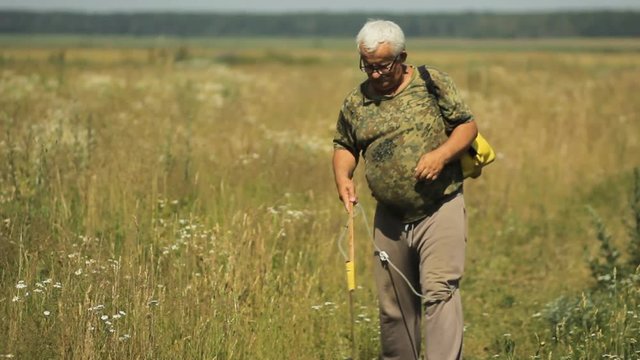Man works with garden spray in the field near home