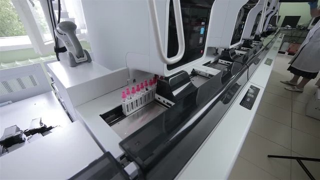 Modern automatic medical hematology analyzer. Test tubes on robotic conveyor. 1080p.