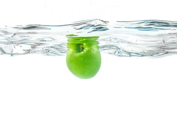 Naklejka na ściany i meble Water splash. Green apple under water. Air bubble and transparen