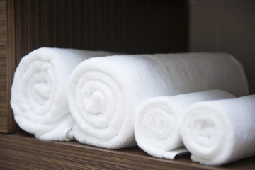 Fototapeta na wymiar rolled white towels on shelf