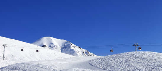 Fototapeta na wymiar Panoramic view on gondola lift and ski slope at nice day