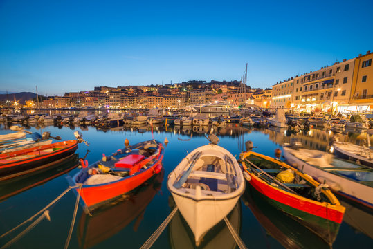 Traditional boats in Portoferraio port and coastline of Elba island in Italy