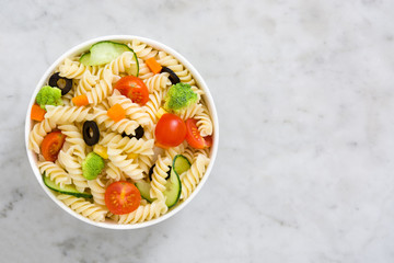 Pasta salad in bowl on marble background
