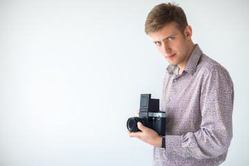 Fototapeta premium Portrait of handsome man with old medium format camera in studio
