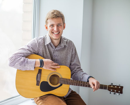 Portrait of handsome smiling man with guitar