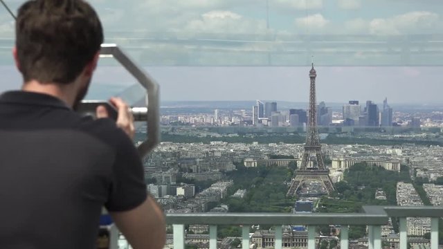 Young Man Enjoys Best Panoramic View Of Paris. The Montparnasse Tower Panoramic Observation Deck has the most beautiful view of Paris