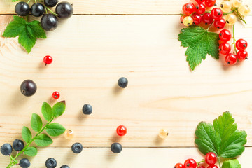 Fototapeta na wymiar border of fresh berries mix on wooden tabletop