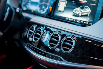 Luxury car interior details. Middle console with air and climate controls