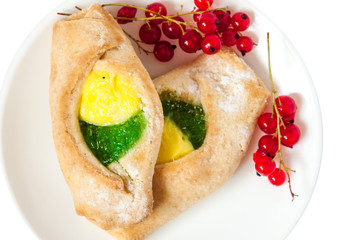 Bake isolated. Scones with jam on a plate. Pastry sprinkled with chocolate. Red currant.