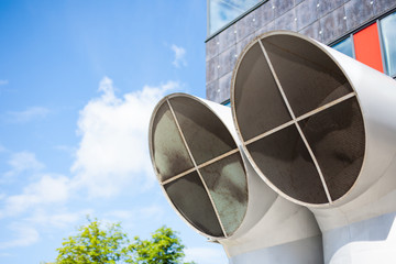 Industrial background of two big modern ventilation pipe tops and blue skies