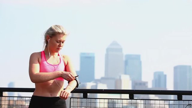 Woman adjusting portable device on arm