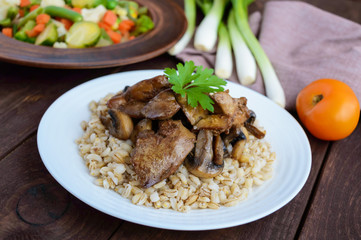 Barley porridge, fried mushrooms and duck liver, boiled quail eggs, tomatoes, arugula - healthy food.