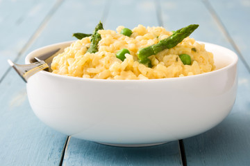 Risotto with asparagus, parsley and peas on a blue wooden table

