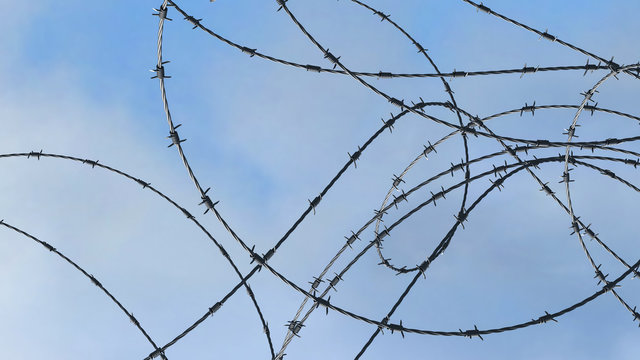 Barbwire over blue sky background