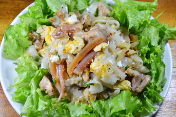stir fried large noodle with chicken and crispy squid on dish