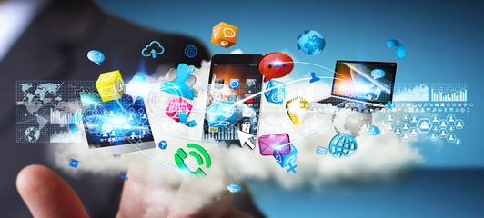 Businessman holding tech devices and icons applications over a c © sdecoret