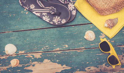 Flipflops, Handtuch, Muscheln und Sonnenbrille auf Holzuntergrund, widescreen, retro
