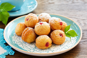 Donuts filled with raspberry jam and powdered sugar in.