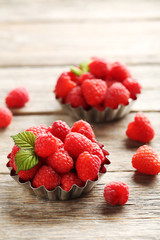 Red raspberries in bowl on a grey wooden table