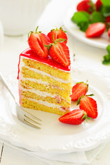 A piece of sponge cake with strawberries and cream.