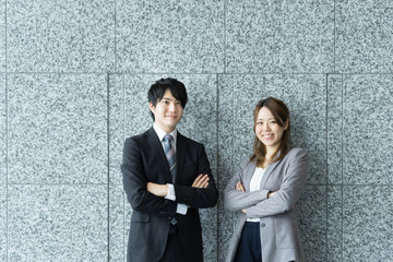 笑顔で腕組する男女（ビジネスイメージ）