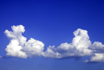 Naklejka na ściany i meble Two cumulus clouds on a blue sky