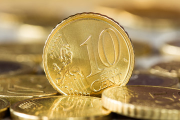Ten euro cent standing between other coins
