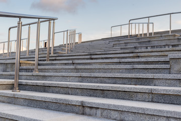 Obraz premium Public metal chrome handrail on gray staircase at city