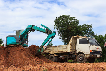 Industrial loader excavator moving earth and unloading on a dumper truck